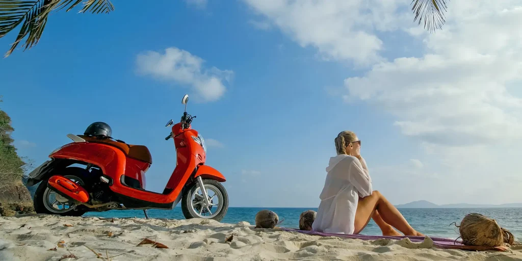 “Girl riding scooter on beach in Thailand”